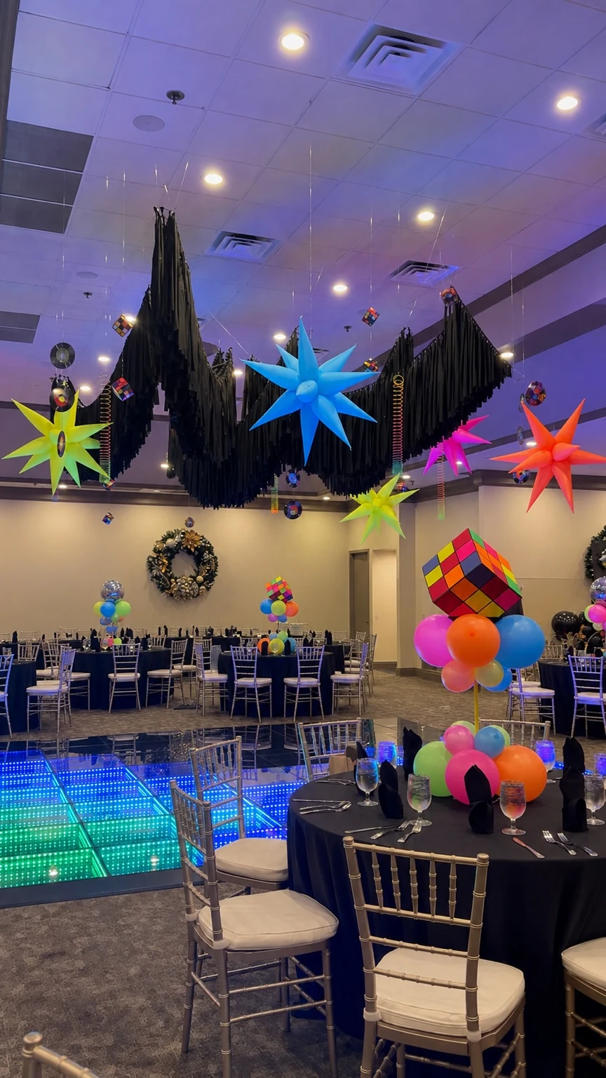 Completed ceiling installation with black fringe, neon stars, records, and hanging coils