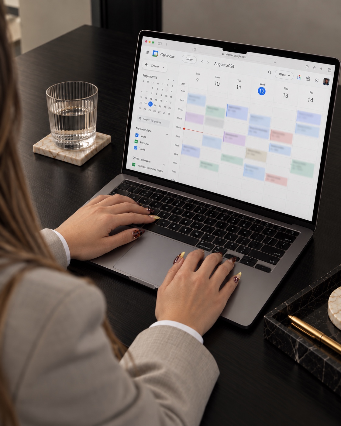 Jenica working at a MacBook with an August 2026 Google Calendar open