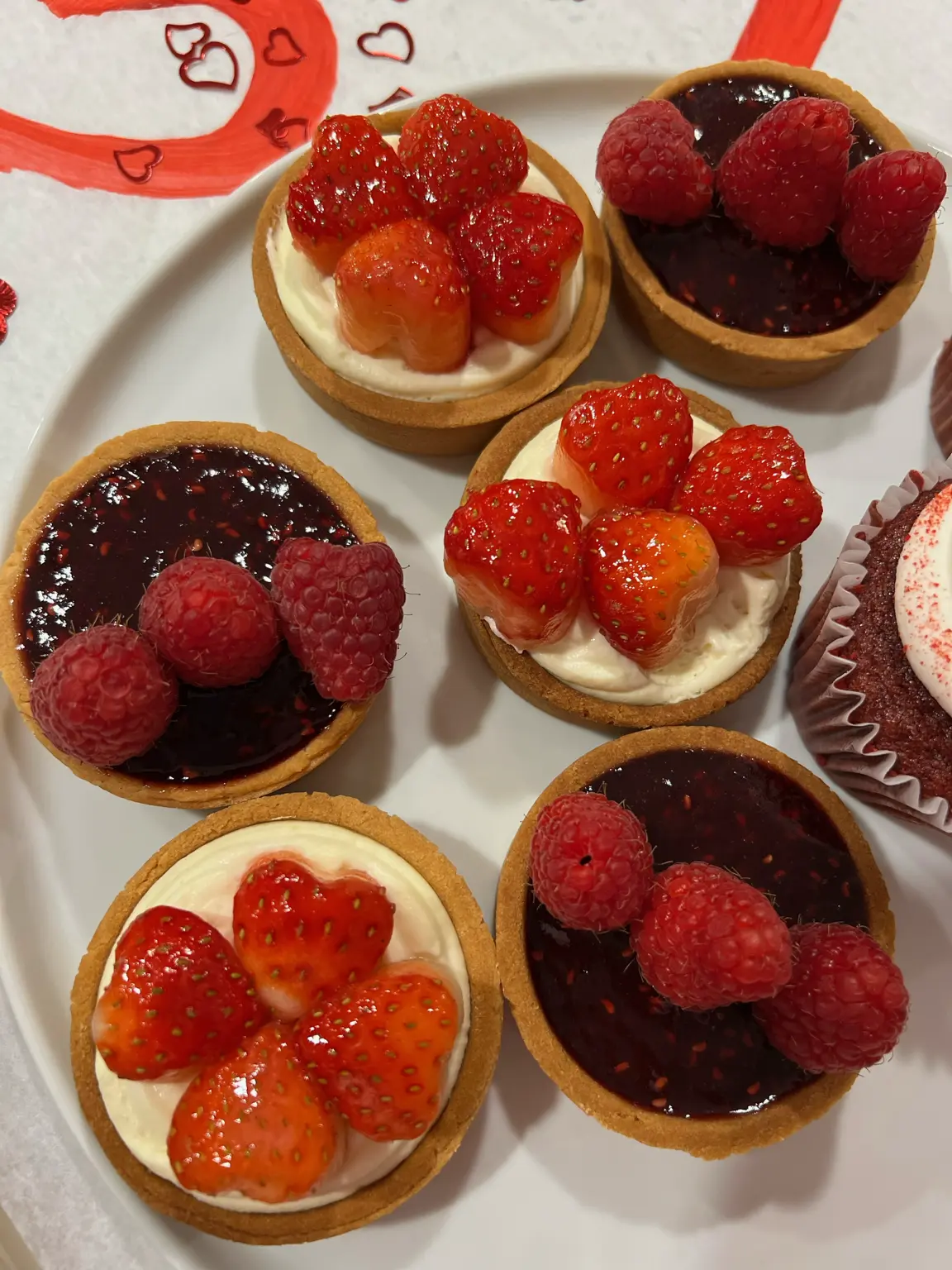 Close-up of strawberry and raspberry tarts on a white plate