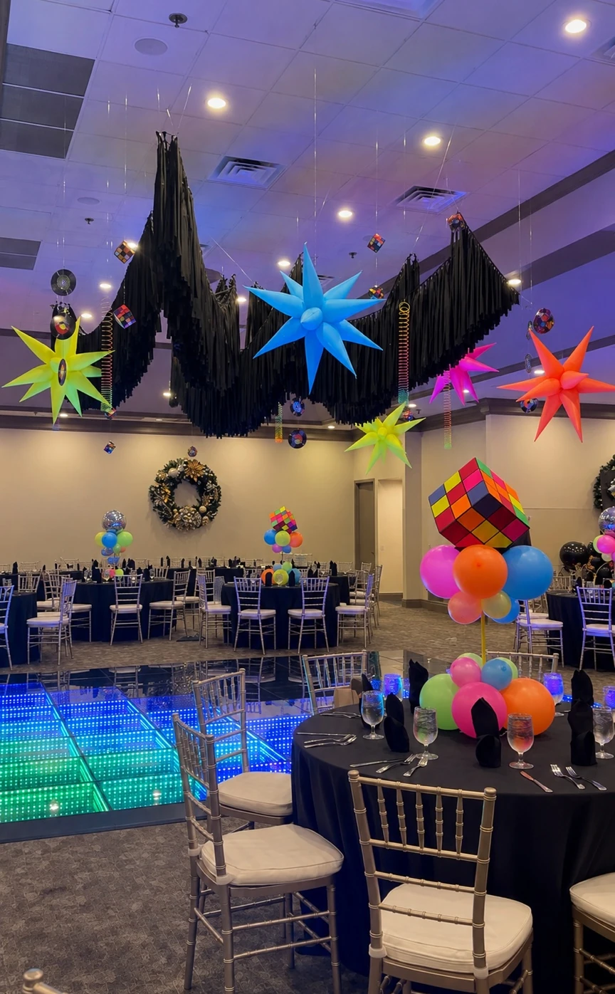 Neon stars and black fringe hanging over the ballroom tables