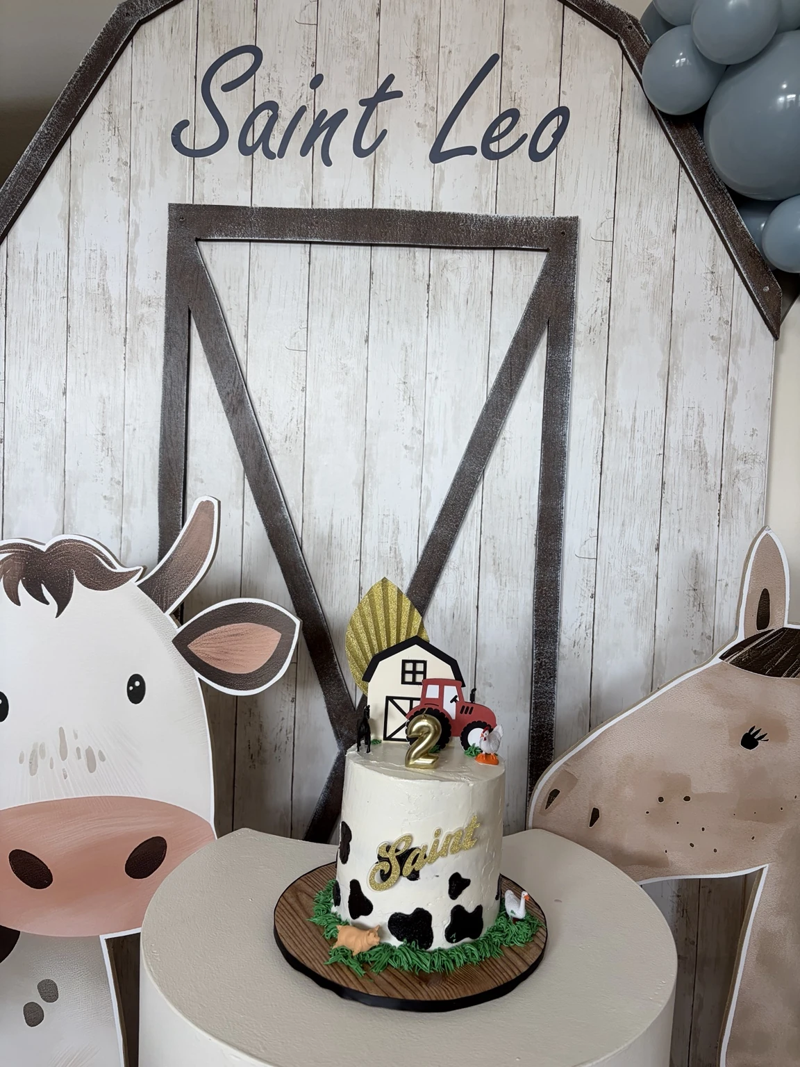 Farm-themed birthday cake in front of the Saint Leo barn backdrop
