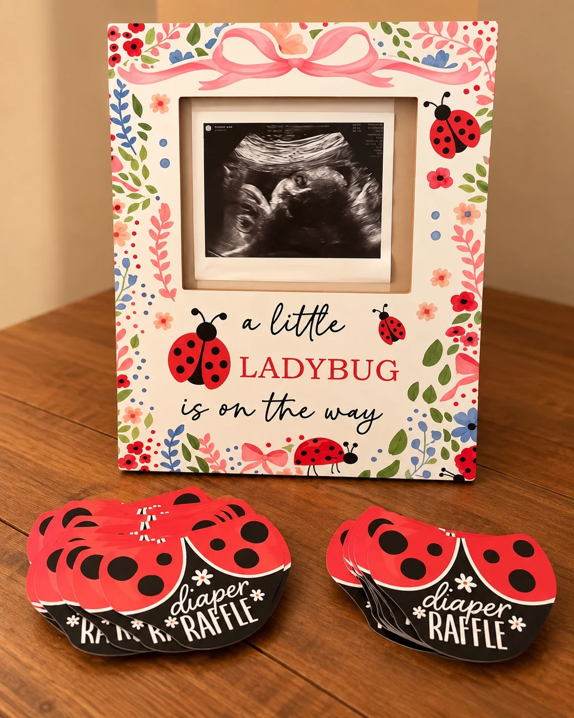 Diaper raffle cards displayed beneath a framed sonogram
