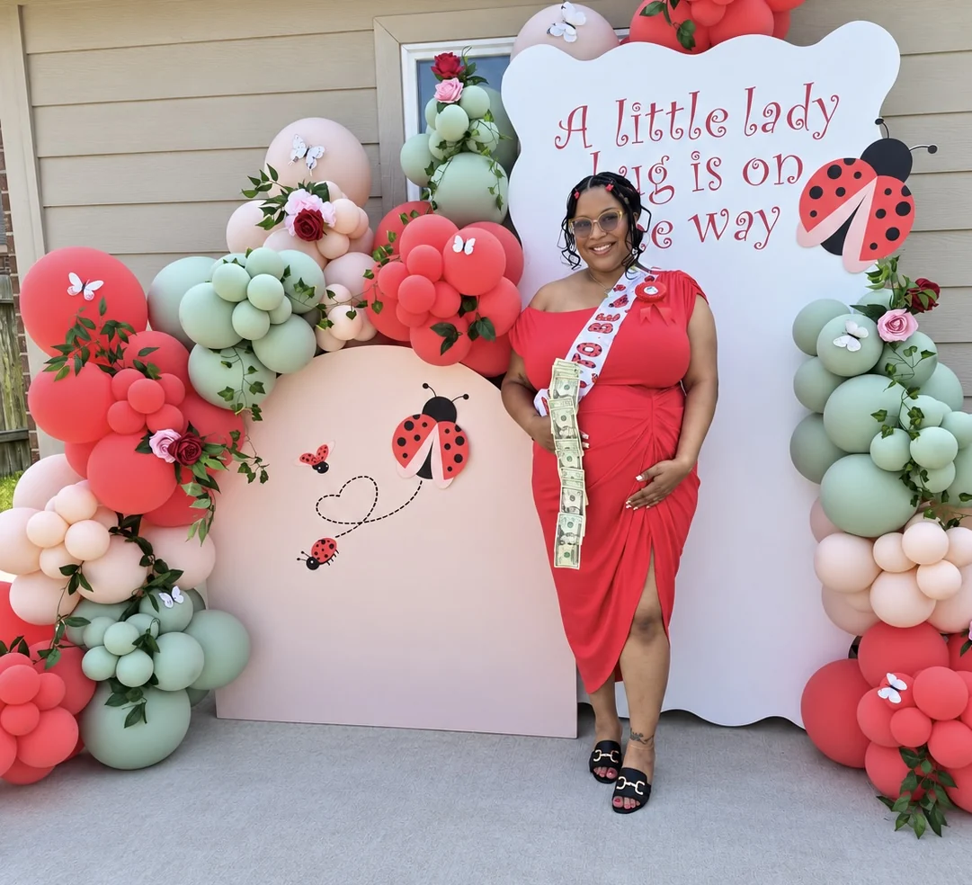 Guest of honor in front of the ladybug baby shower backdrop