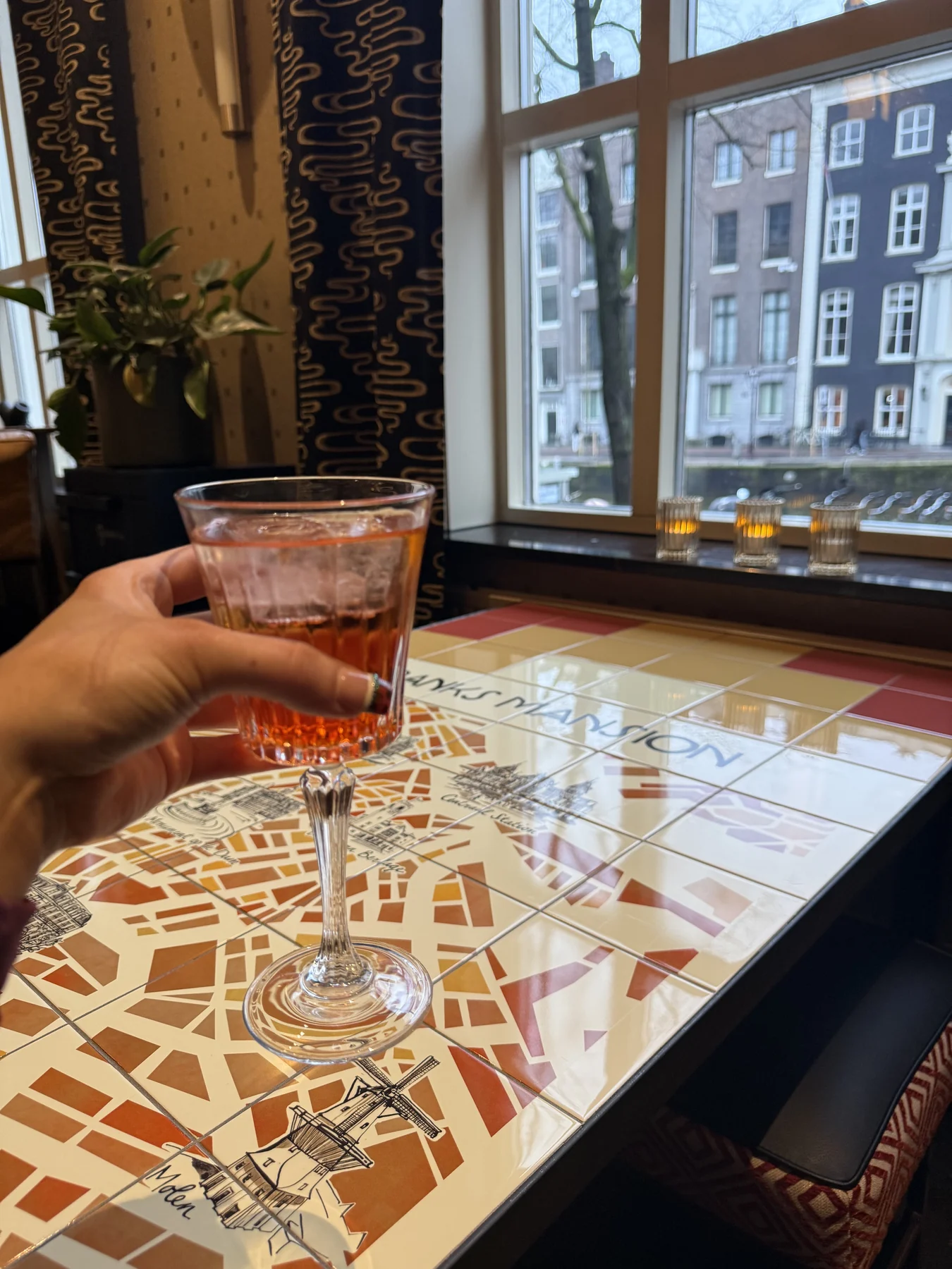 An Aperol spritz over the map table inside Banks Mansion