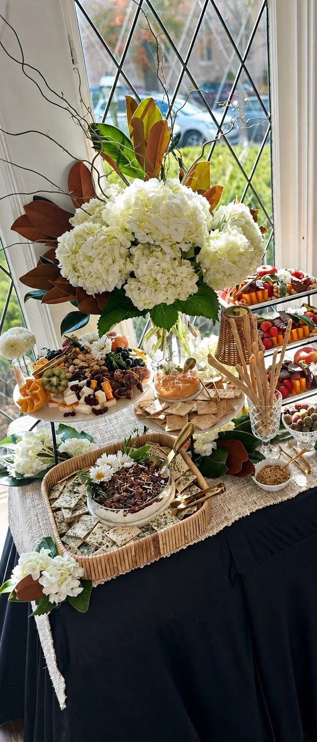 Completed full grazing-table display with florals, charcuterie, dips, and coordinated food styling