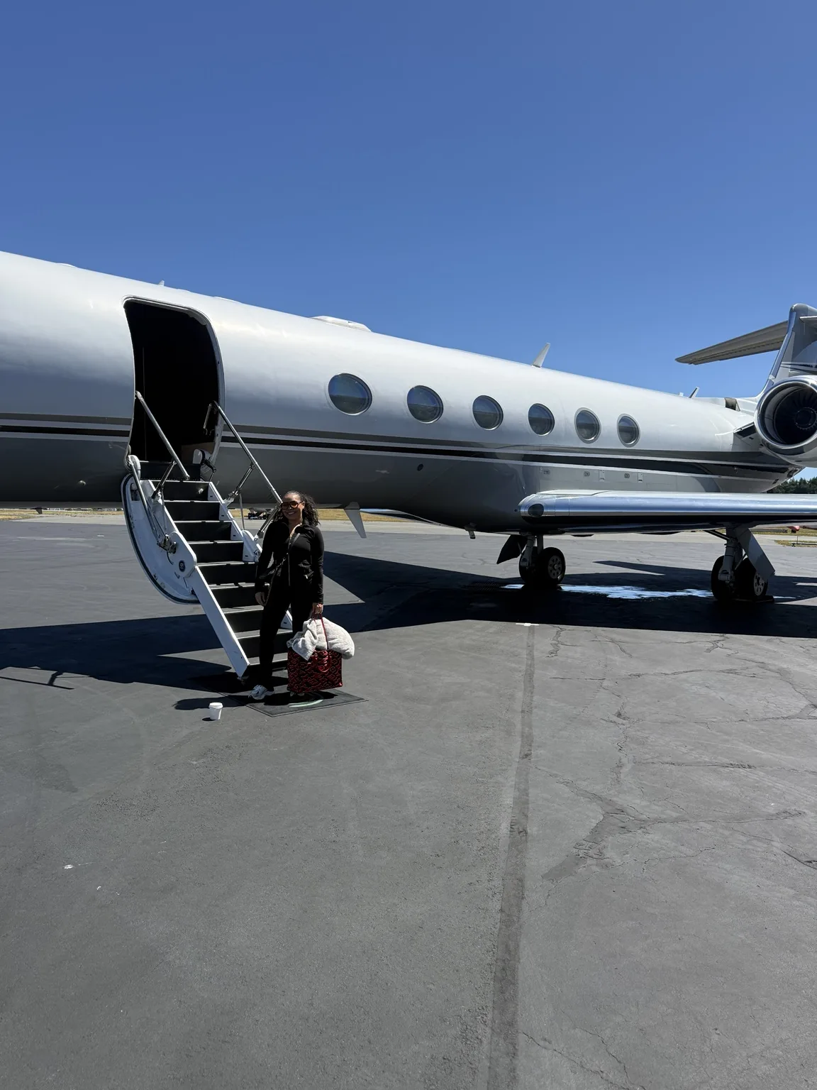 Full-color private aviation moment beside aircraft stairs